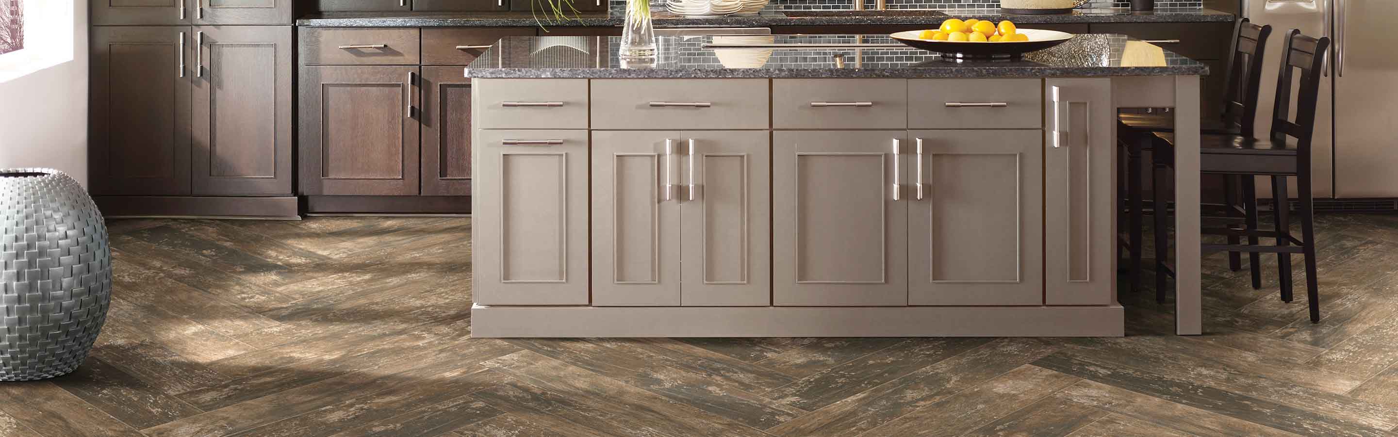 wood-look tile in kitchen with brown cabinetry